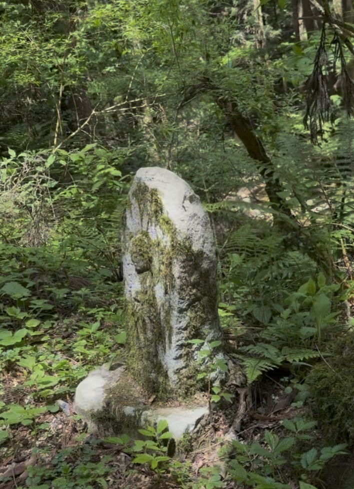 A stone Jizo wearing a red bib along the Nakasendo
